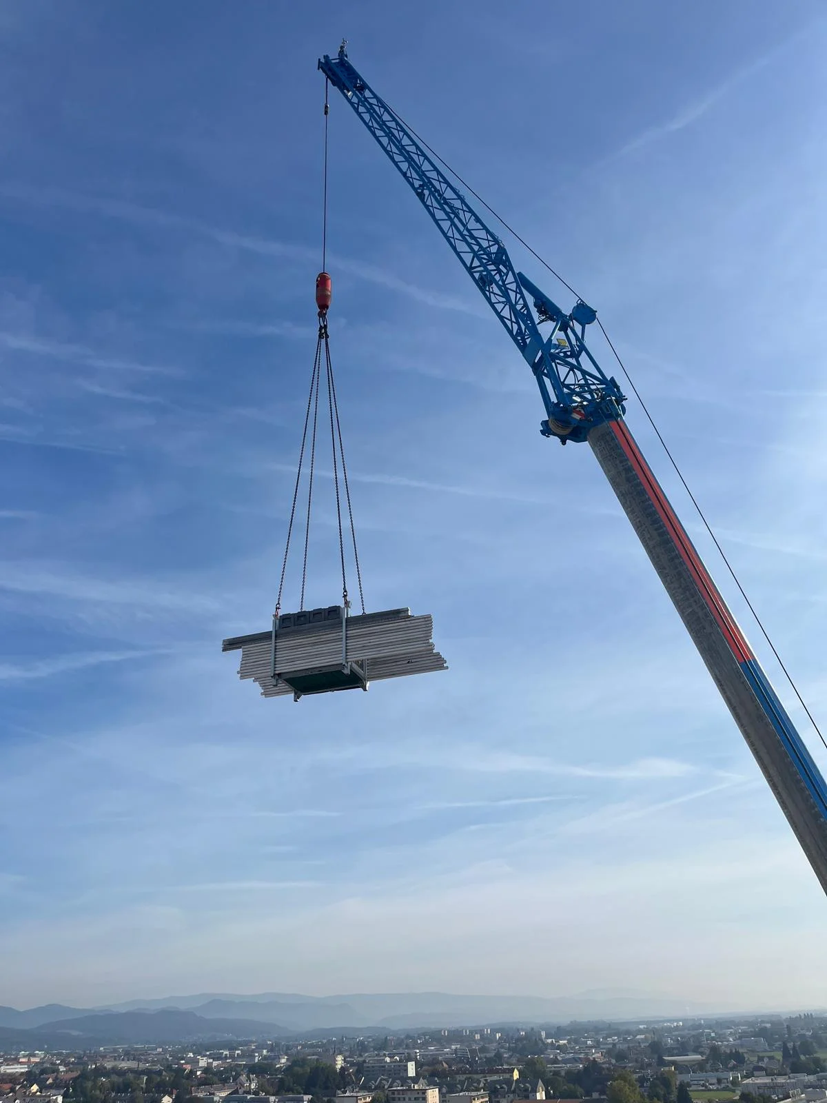 Kran hebt Material über die Stadt zum Dach des Lagerhauses