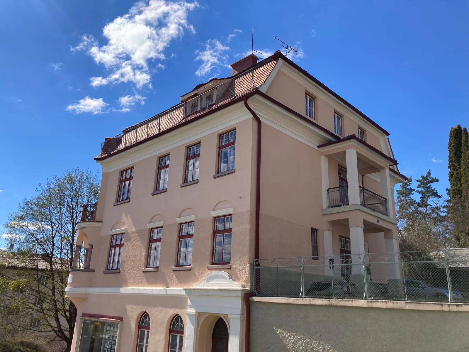 Villa mit versetzten roten Dachflächen und unterschiedlich hohen Gebäudeteilen