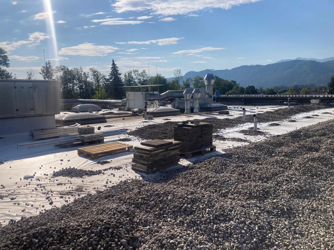 Kies, Material und Dachaufbauten während der Arbeiten – Kiesflachdach in Klagenfurt