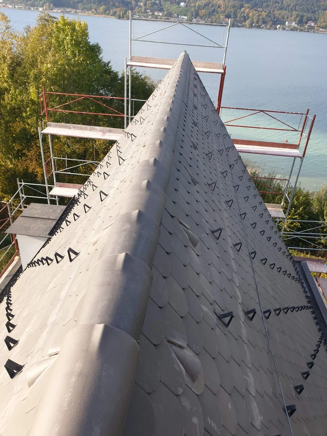Blick entlang des eingedeckten Dachfirsts mit dem Wörthersee im Hintergrund
